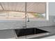 Close-up of a kitchen sink, featuring modern fixtures and a backsplash under a bright window at 804 Vincent Way, Las Vegas, NV 89145