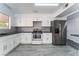 Modern kitchen with stainless steel appliances, white cabinets, and gray backsplash at 804 Vincent Way, Las Vegas, NV 89145