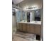 Bathroom view showcasing double sinks with light wood cabinetry and a walk-in shower at 807 Zinnia Cir, Henderson, NV 89015