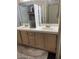 Bathroom view showcasing double sinks with light wood cabinetry and a walk-in shower at 807 Zinnia Cir, Henderson, NV 89015