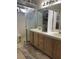 Bathroom view showcasing double sinks with light wood cabinetry and a walk-in shower at 807 Zinnia Cir, Henderson, NV 89015