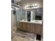 Bathroom view showcasing double sinks with light wood cabinetry and a walk-in shower at 807 Zinnia Cir, Henderson, NV 89015