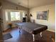 Game room with a covered pool table, large window with shutters, and neutral paint colors at 9204 Gentle Cascade Ave, Las Vegas, NV 89178