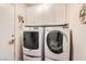 Bright laundry room with front-loading washer and dryer and upper white cabinets at 9204 Gentle Cascade Ave, Las Vegas, NV 89178