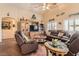 Cozy living room with leather furniture, a ceiling fan, and abundant natural light at 9204 Gentle Cascade Ave, Las Vegas, NV 89178