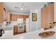 Bright kitchen featuring wood cabinets, white appliances, and a seamless breakfast bar at 9564 Belle Fountain Ave, Las Vegas, NV 89123