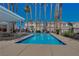 Community pool surrounded by tall palm trees, tables, and seating area at 9564 Belle Fountain Ave, Las Vegas, NV 89123