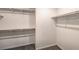 A well-lit walk-in closet featuring carpeted floors and wood shelving and closet rods for easy storage at 9938 Ullom Dr # Lot 6, Las Vegas, NV 89141