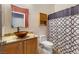 Well-lit bathroom with a modern vanity, vessel sink, toilet, and patterned shower curtain at , Las Vegas, NV 89131