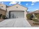 Beige home with gray garage door, desert landscaping in the front and a tile roof at 7400 Quail Heights Ave, Las Vegas, NV 89131