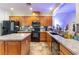 Bright kitchen featuring granite counters, an island, tile flooring and black appliances at 7400 Quail Heights Ave, Las Vegas, NV 89131