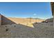 The gravel backyard is fenced in with a brick wall and has an outdoor seating area at 10026 Honey Rose Ave, Las Vegas, NV 89143