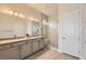 Contemporary bathroom showcasing double sinks, sleek cabinetry, and a glass-enclosed shower with a built-in seat at 10026 Honey Rose Ave, Las Vegas, NV 89143