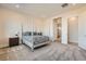 Inviting bedroom featuring a four-poster bed, soft carpet, and access to an en-suite bathroom at 10026 Honey Rose Ave, Las Vegas, NV 89143