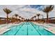 Resort-style community pool with palm trees and lounge chairs, offering a luxurious outdoor experience at 10026 Honey Rose Ave, Las Vegas, NV 89143