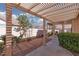 Inviting back patio with pergola, manicured landscaping, and perfect for outdoor entertaining at 10300 Pinto Creek Ln, Las Vegas, NV 89144