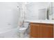 Cozy bathroom with a shower-tub combo, light colored tile and wood vanity at 10300 Pinto Creek Ln, Las Vegas, NV 89144