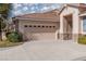 A two-car garage featuring stone accents and a driveway at 10300 Pinto Creek Ln, Las Vegas, NV 89144