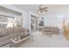 Open living room with neutral carpet, ceiling fan, and sliding glass doors to the backyard at 10300 Pinto Creek Ln, Las Vegas, NV 89144