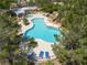 Aerial view of a resort-style community pool, surrounded by lush greenery and lounge areas at 10300 Pinto Creek Ln, Las Vegas, NV 89144