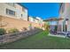 Landscaped backyard with retaining wall, artificial turf, patio, and shade umbrella at 10393 Rose Palisade St, Las Vegas, NV 89141