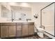 Modern bathroom featuring double sinks, sleek fixtures, and a glass-enclosed shower enhancing the luxurious feel at 10393 Rose Palisade St, Las Vegas, NV 89141