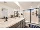 Modern bathroom featuring double sinks, sleek fixtures, and a glass-enclosed shower enhancing the luxurious feel at 10393 Rose Palisade St, Las Vegas, NV 89141