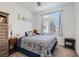 Bright bedroom featuring a comfortable bed with stylish bedding and ample natural light from a large window at 10393 Rose Palisade St, Las Vegas, NV 89141