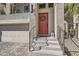Close-up of home's entrance showing a red door with a wreath, metal railings, and stone steps at 10393 Rose Palisade St, Las Vegas, NV 89141