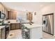 Bright kitchen showcasing a center island with barstool seating, stainless appliances, and neutral cabinetry at 10393 Rose Palisade St, Las Vegas, NV 89141