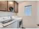 Well-lit laundry room with modern washer and dryer, ample cabinet space, and decorative wreath at 10393 Rose Palisade St, Las Vegas, NV 89141