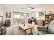 Bright living room with a sliding glass door to the yard, cozy seating, and a ceiling fan at 10393 Rose Palisade St, Las Vegas, NV 89141