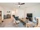 Comfortable living room with ceiling fan, neutral carpet, TV, and cozy seating arrangement at 10393 Rose Palisade St, Las Vegas, NV 89141