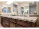 Primary bathroom with dual sinks, granite countertops, and dark wood cabinets offers a modern feel at 10507 Bryn Haven Ave, Las Vegas, NV 89135