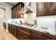 Close-up of stovetop with stainless steel range hood and granite counters at 10507 Bryn Haven Ave, Las Vegas, NV 89135