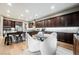 Modern kitchen featuring dark wood cabinets, granite countertops, stainless steel appliances, and a breakfast nook at 10507 Bryn Haven Ave, Las Vegas, NV 89135