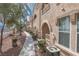 Condominium exterior featuring balconies, arched entryways, and manicured landscaping along the walkway at 10550 W Alexander Rd # 2057, Las Vegas, NV 89129