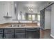 A kitchen featuring black cabinetry, stainless steel sink, and a view of the living room through a cutout at 10550 W Alexander Rd # 2057, Las Vegas, NV 89129