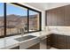 Gourmet kitchen with stainless steel appliances, a farmhouse sink, and stunning views of the surrounding landscape at 1057 Giovanni Ln, Henderson, NV 89012