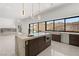 Modern kitchen featuring a waterfall island, stainless steel appliances, and large windows with mountain views at 1057 Giovanni Ln, Henderson, NV 89012