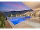 Stunning pool and spa featuring elegant tile work and meticulous landscaping at twilight at 1057 Giovanni Ln, Henderson, NV 89012