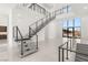 Grand staircase with sleek metal railings and large windows offering scenic views at 1057 Giovanni Ln, Henderson, NV 89012