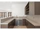 Modern wet bar with gray countertops, stylish cabinetry, stainless steel beverage cooler, and mountain views at 1057 Giovanni Ln, Henderson, NV 89012
