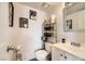 Cozy bathroom with a single sink vanity, toilet, and decorative wall decor and metal shelf at 1228 Mews Ln, Las Vegas, NV 89101