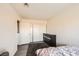 Minimalist bedroom design with laminate wood floors, dark-colored dresser, and closet with bi-fold doors at 1228 Mews Ln, Las Vegas, NV 89101