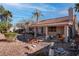 Landscaped backyard with desert rocks, mature trees, covered patio and small decorative bridge at 1270 Del Lilly Ln, Las Vegas, NV 89123