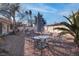 Desert landscaped backyard with mature palm trees and dining table with umbrella at 1270 Del Lilly Ln, Las Vegas, NV 89123