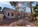 Low maintenance backyard with desert landscaping, mature trees and dining table with umbrella at 1270 Del Lilly Ln, Las Vegas, NV 89123