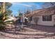 Low maintenance backyard with desert landscaping, mature trees and dining table with umbrella at 1270 Del Lilly Ln, Las Vegas, NV 89123