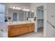 Bathroom showcasing a double sink vanity, large mirror, and access to a spacious closet at 1270 Del Lilly Ln, Las Vegas, NV 89123
